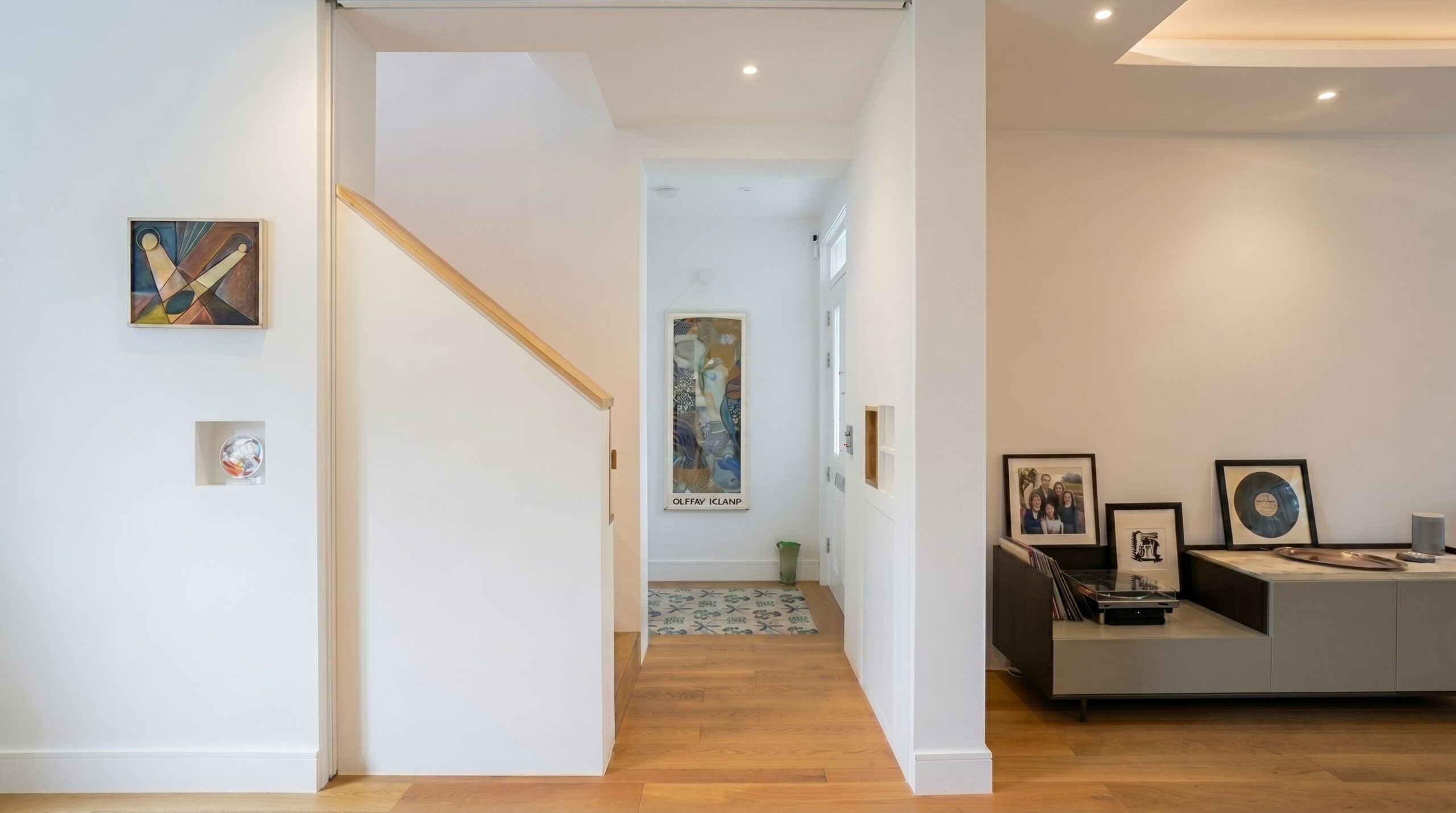 Entrance hallway of a renovated Victorian house with bespoke staircase, integrated joinery, vinyl record storage and curated artworks, Islington London