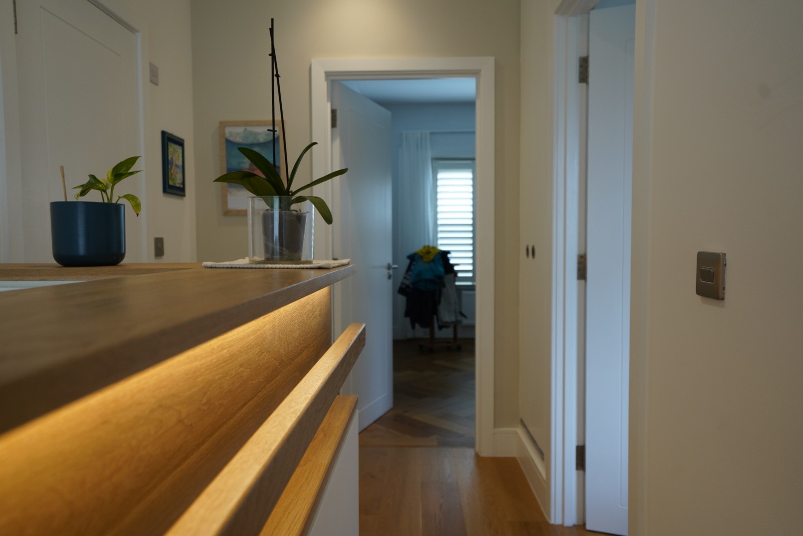 Upper floor landing with illuminated oak handrail, herringbone parquet flooring and orchid detail leading to the bedrooms, Islington London