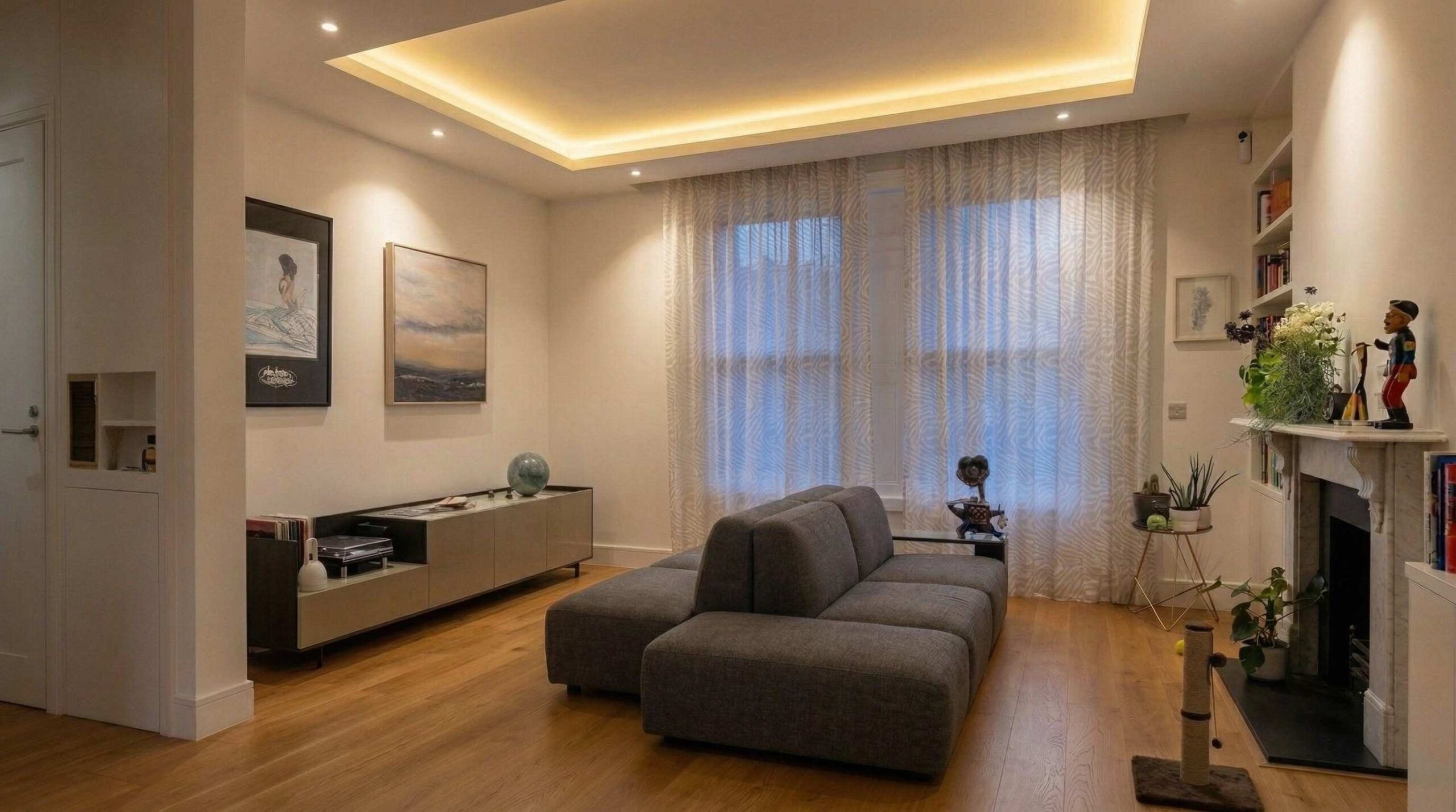 Period property living room with bespoke recessed cove lighting, modular grey sofa and original marble fireplace in a whole house renovation, Islington London